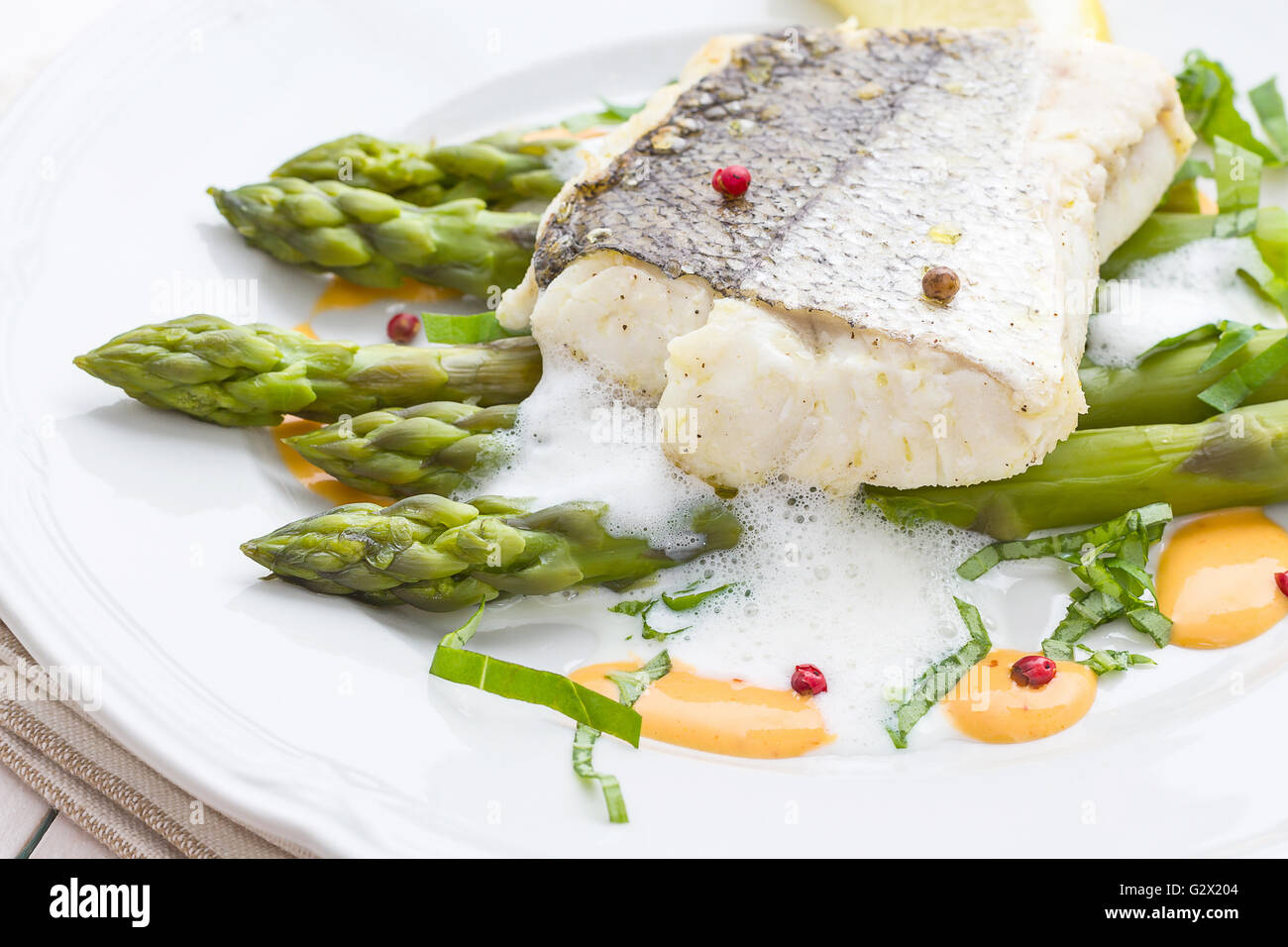Filetto di nasello con asparagi verdi di schiuma e salsa di limone Foto Stock