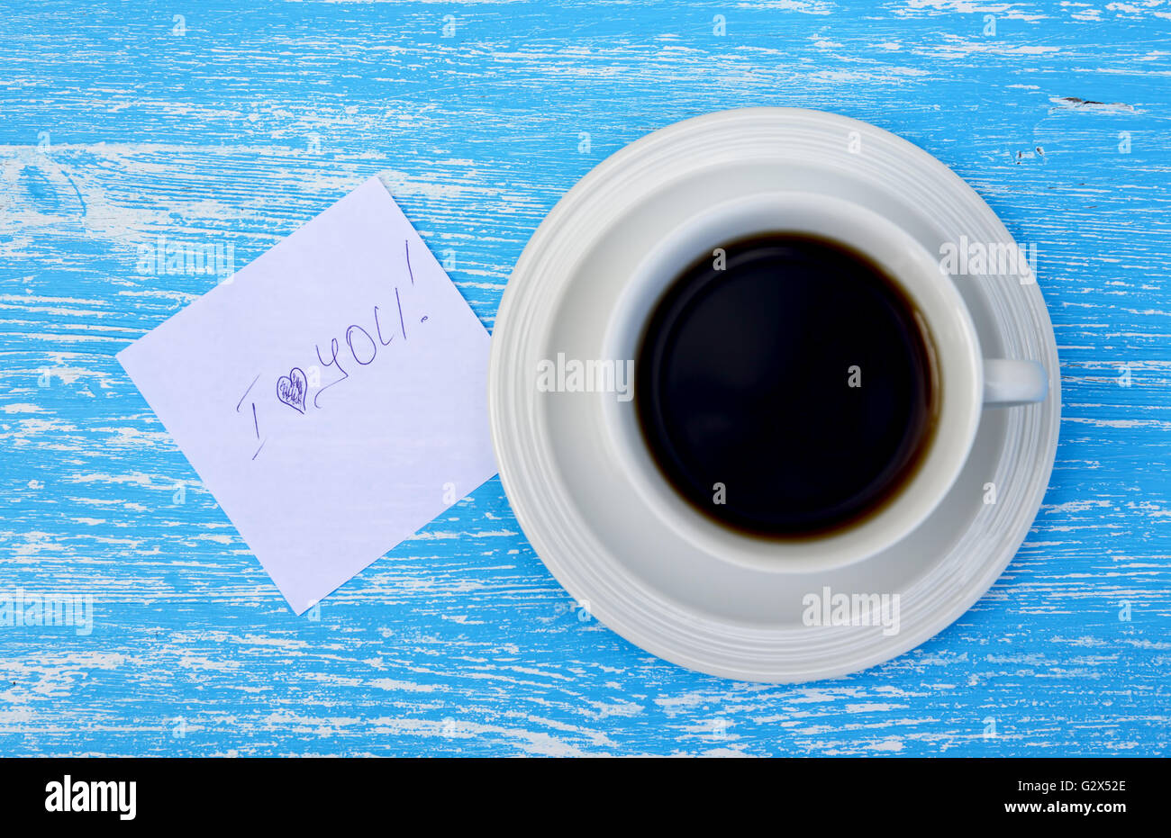 Tazza di tè con buona mattina nota su rustiche in legno di colore blu sullo sfondo. Vista superiore Foto Stock