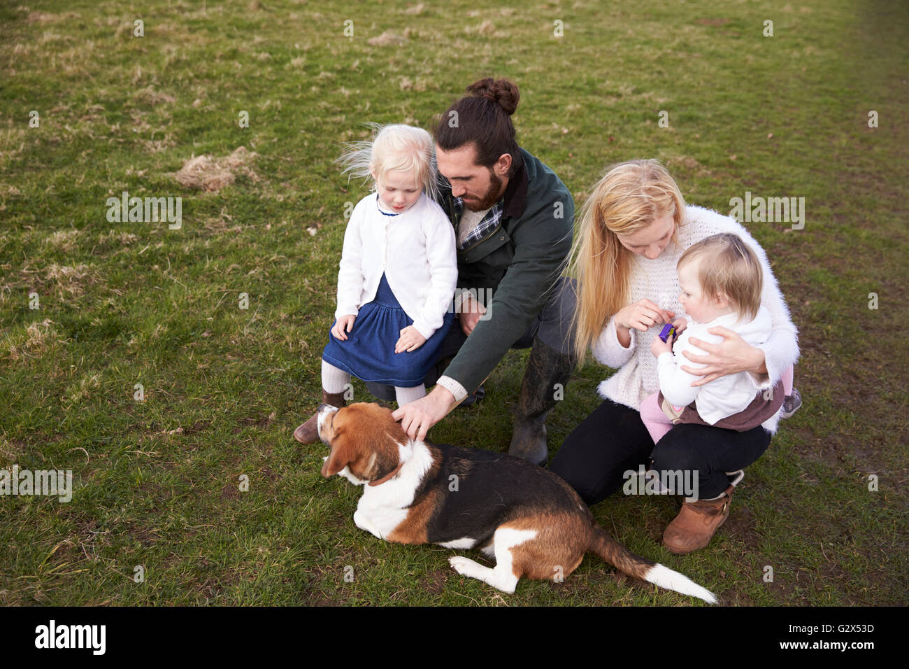 Famiglia in inverno il paese a piedi con il cane Foto Stock