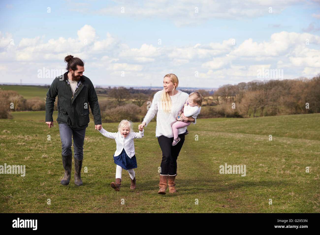 Famiglia tenendo le mani sul paese invernale a piedi Foto Stock