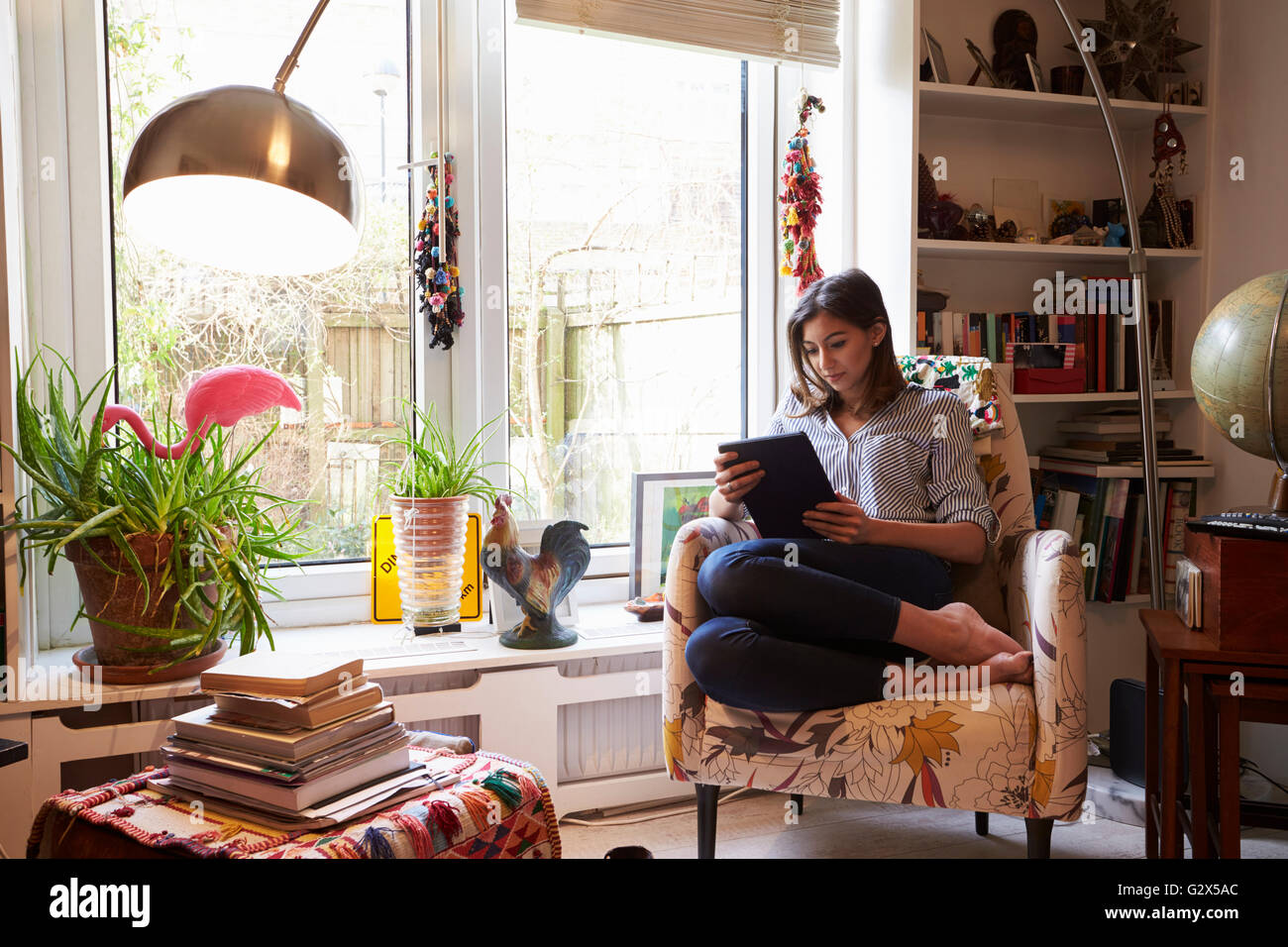 Donna rilassante con tavoletta digitale In elegante appartamento Foto Stock