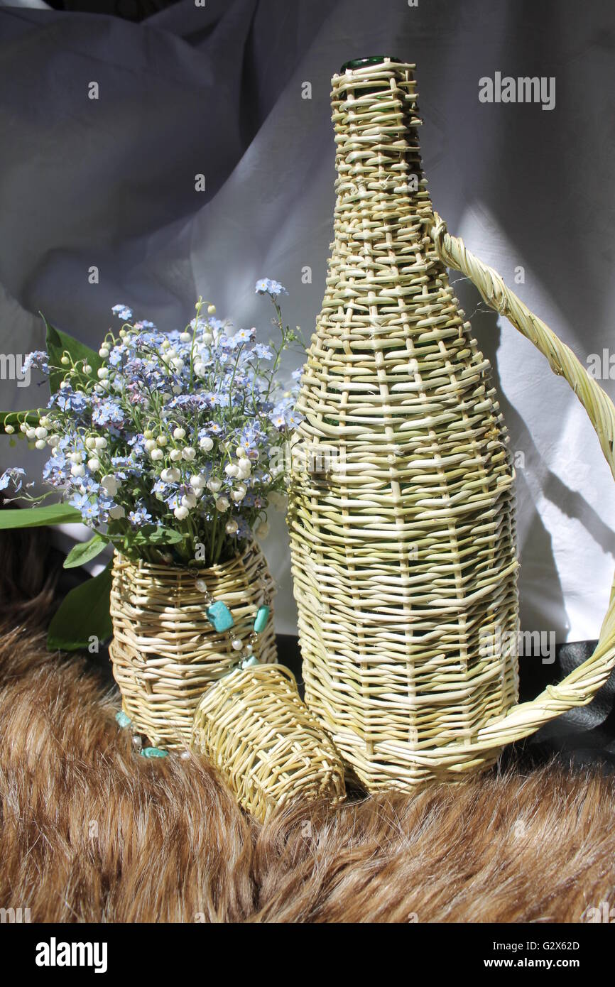 Artigianato prodotti dalla bottiglia di salice, un bicchiere, un vaso con fiori di primavera decorazione per la casa Foto Stock