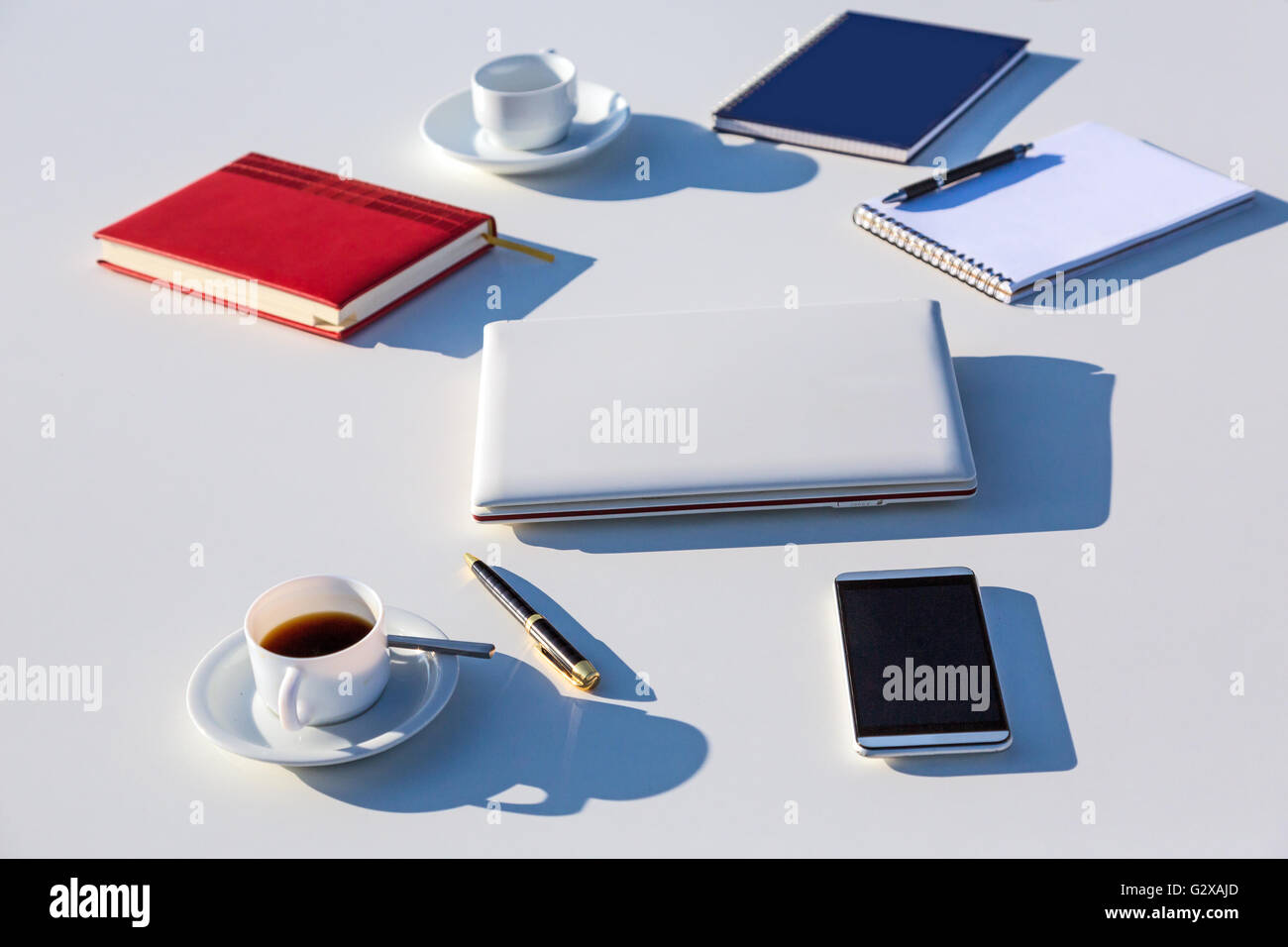 Selezione di oggetti business sul tavolo bianco all'aperto alla luce del sole Foto Stock