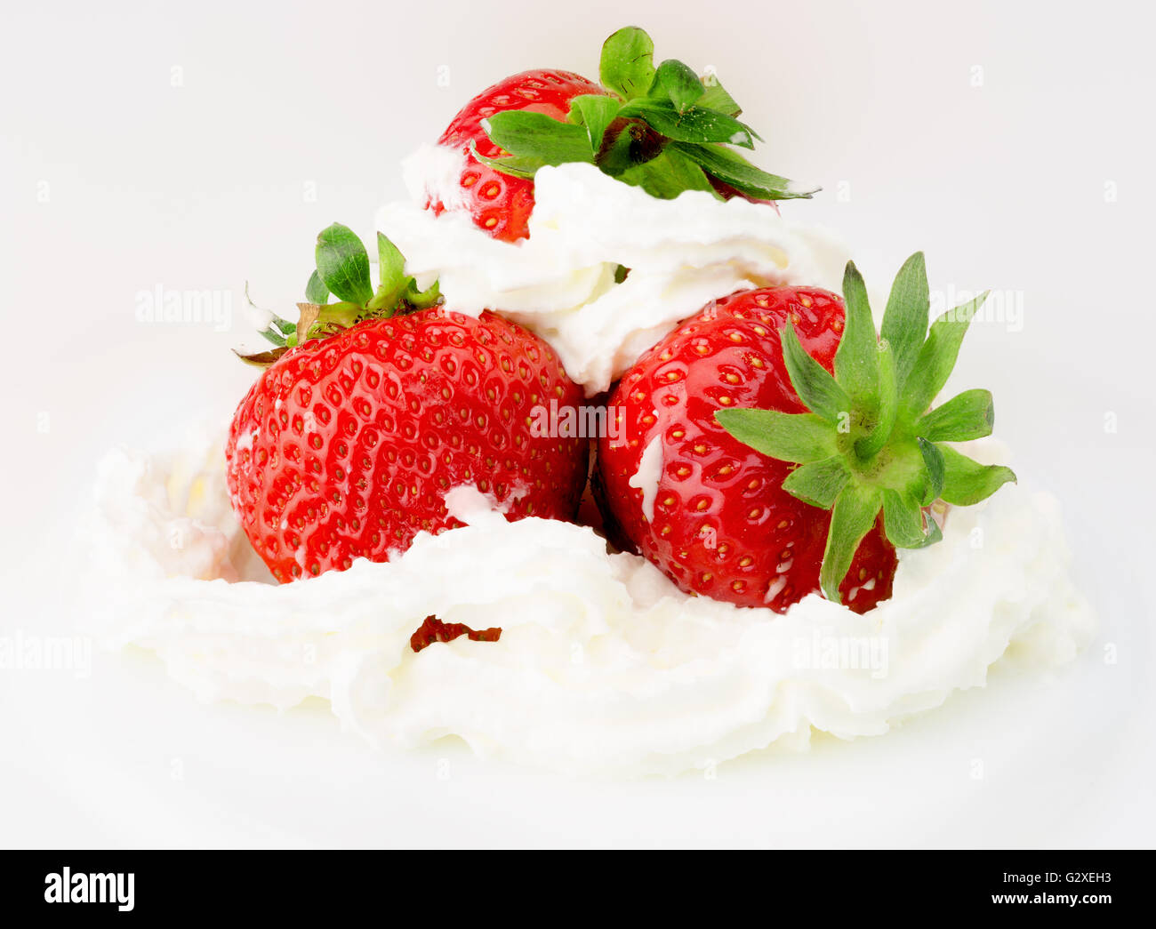 Fragole con panna montata isolata su uno sfondo bianco. Foto Stock