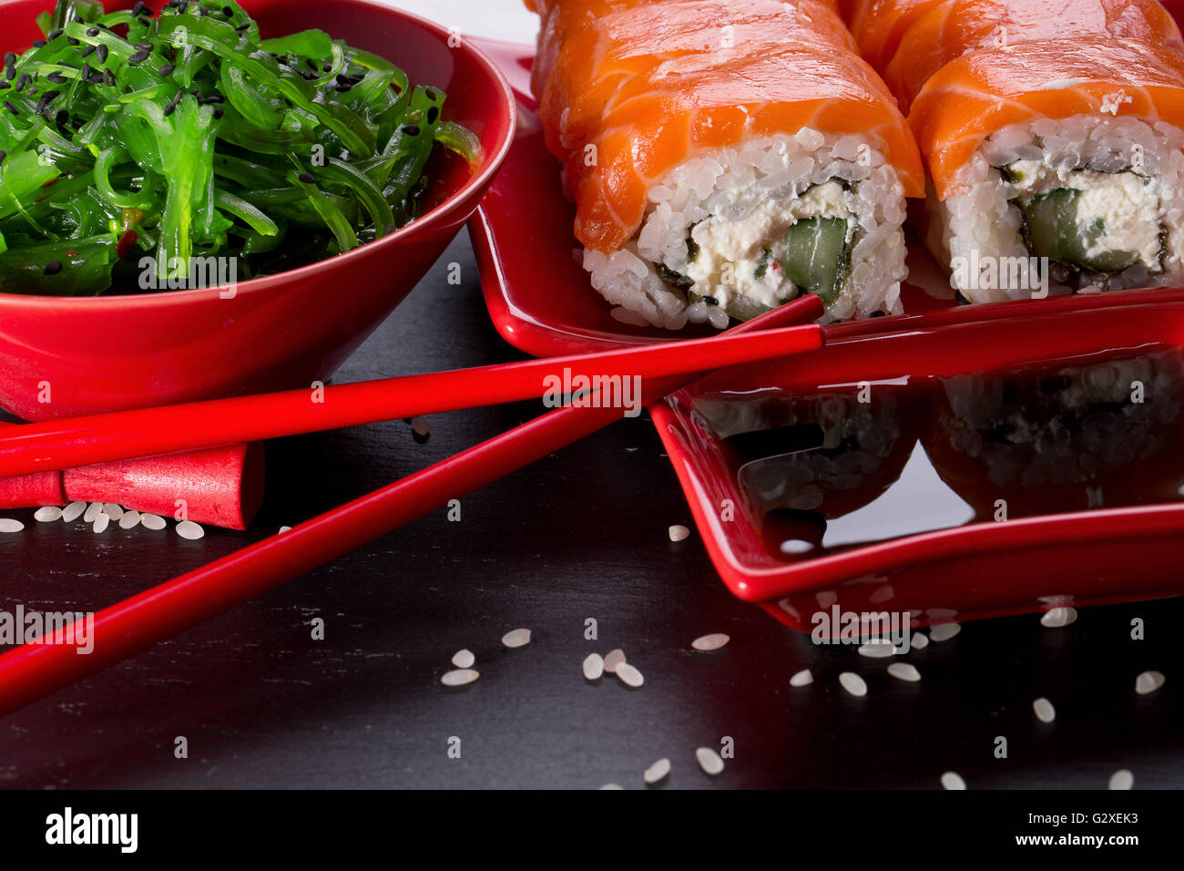 Il sushi e panini con verde insalata di mare su una tavola di ardesia. Foto Stock