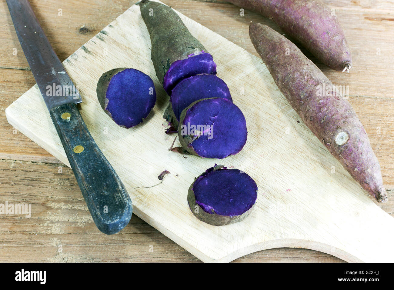 Viola al vapore patata dolce split su legno Foto Stock