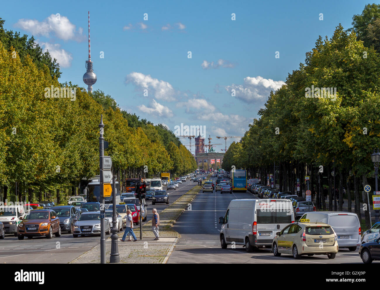 Guardando lungo la strada B5 nel Tiergarten verso la porta di Brandeburgo con la torre della TV che appare sopra gli alberi in lontananza, Berlino, Germania Foto Stock