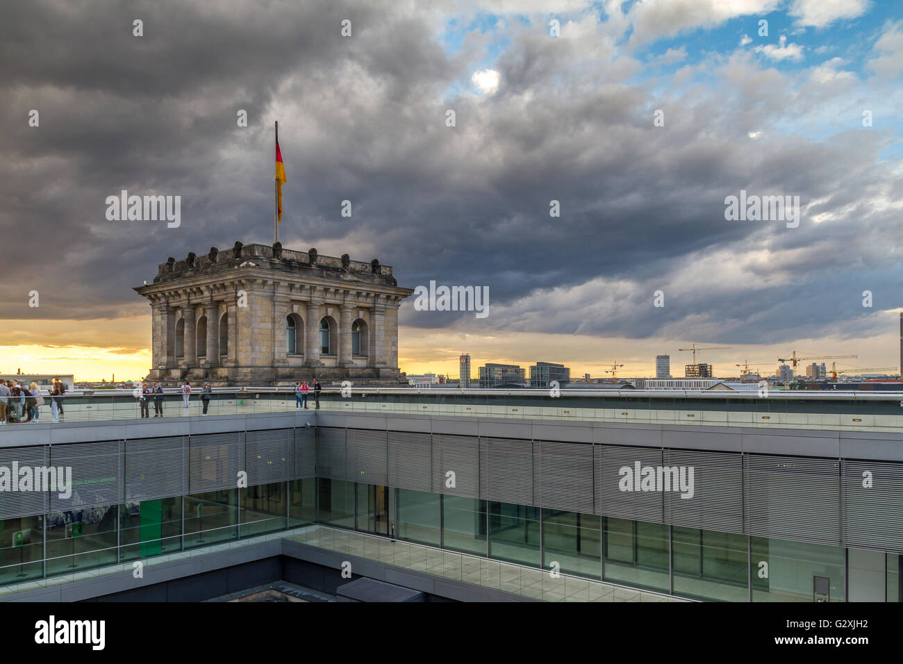 Cieli tempestosi sopra le persone sul tetto del Reichstag Building, che ospita il Bundestag tedesco o Parlamento tedesco a Berlino, Germania Foto Stock