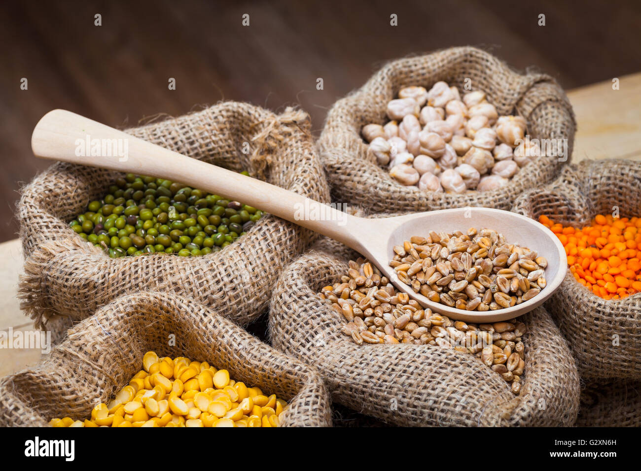 Sacchetti di Hesse a secco con piselli, ceci, lenticchie rosse, frumento e verde mung sul tavolo da cucina Foto Stock