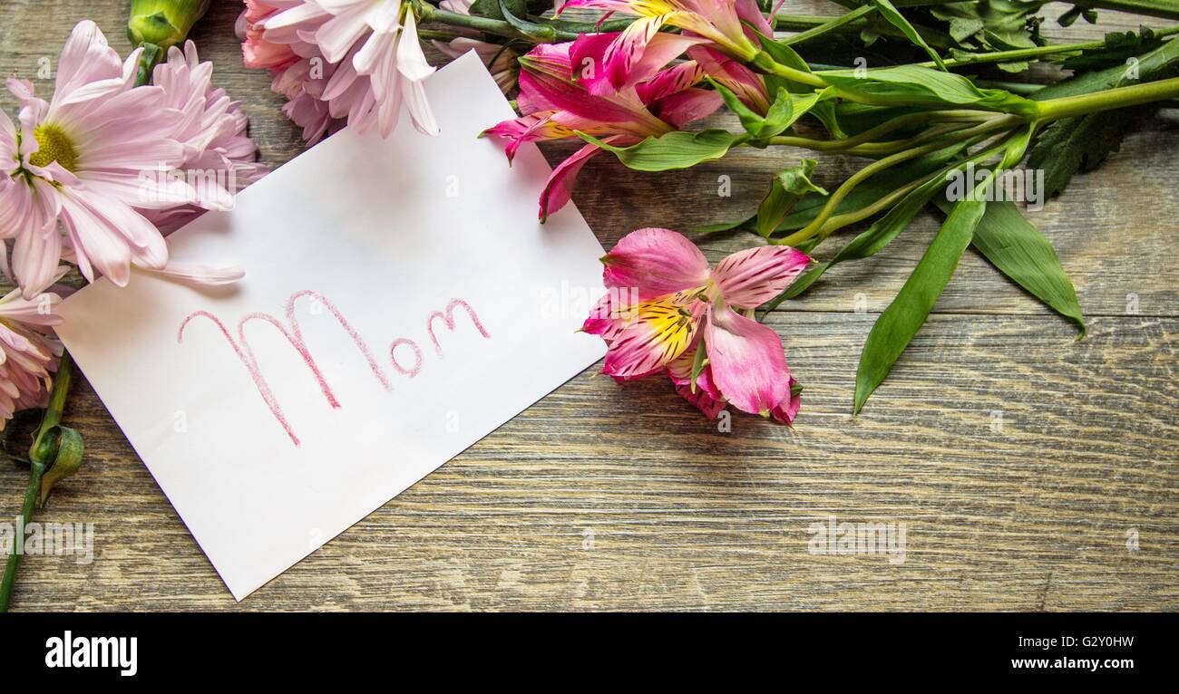 Giornata della madre Card con un bouquet. Busta con etichetta manoscritta e un mazzo di fiori freschi in orientamento panoramico. Shot Foto Stock
