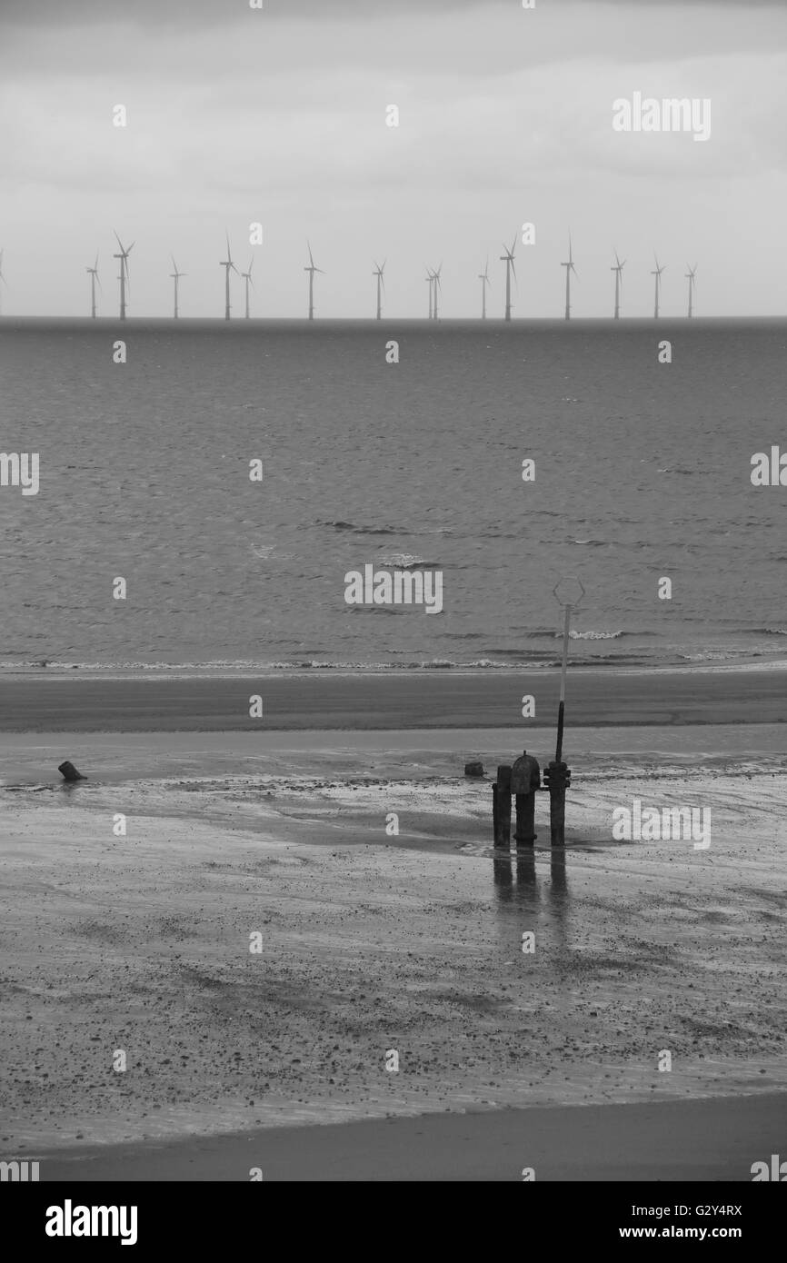 Una centrale eolica in un giorno grigio lontano fuori in mare a Skegness Foto Stock