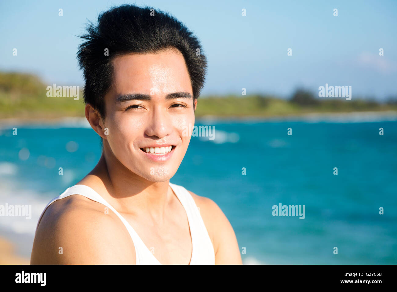 Sorridente giovane uomo sulla spiaggia Foto Stock