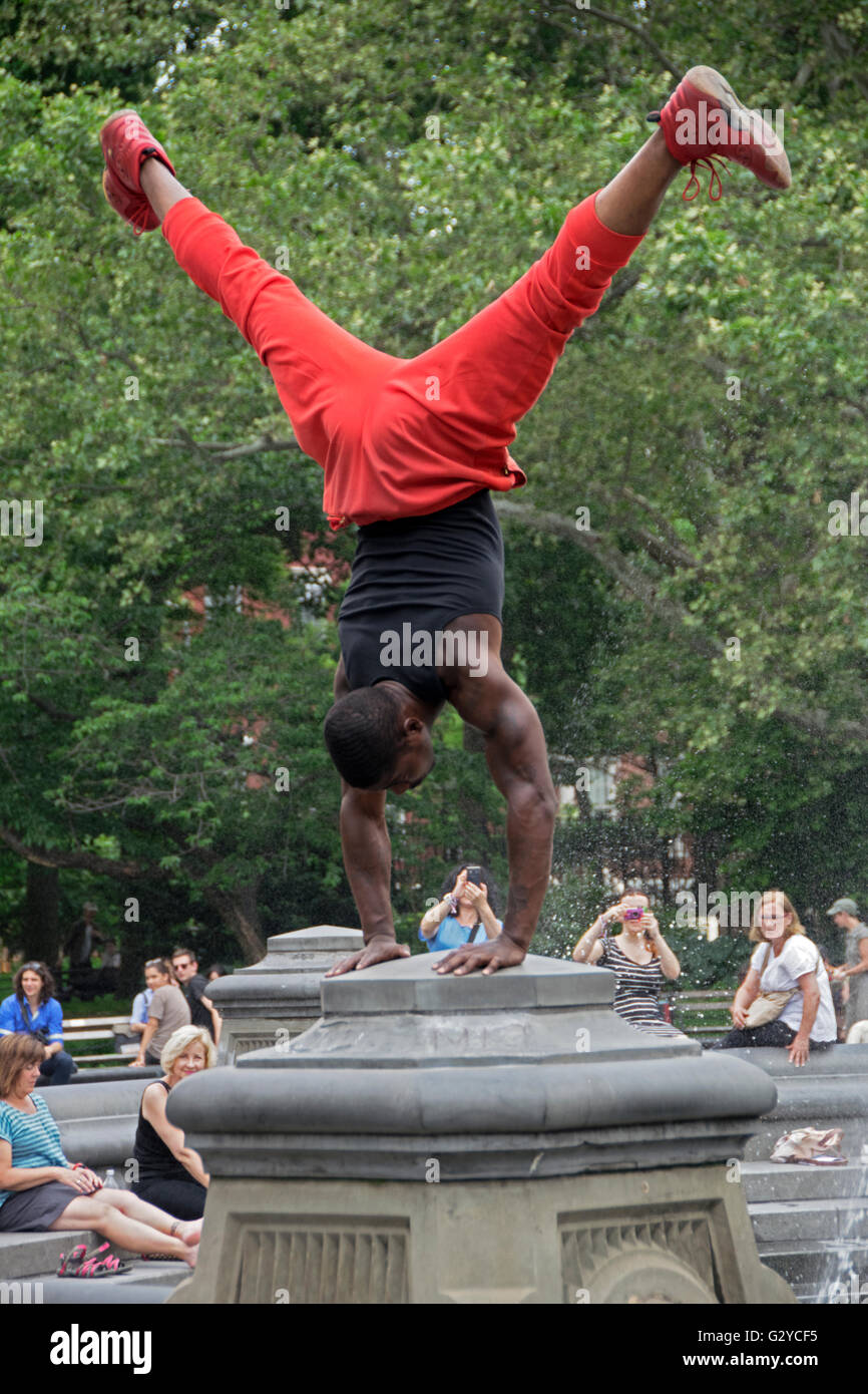 Un ballerino e Acrobat esegue per le donazioni a Washington Square Park nel Greenwich Village a Manhattan, New York City Foto Stock