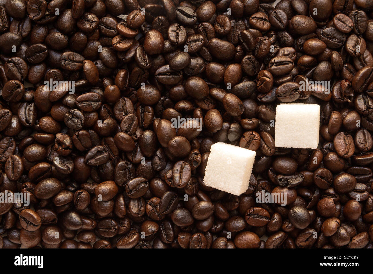 Pezzi di zucchero bianco nel caffè torrefatto fagioli sfondo marrone Foto Stock