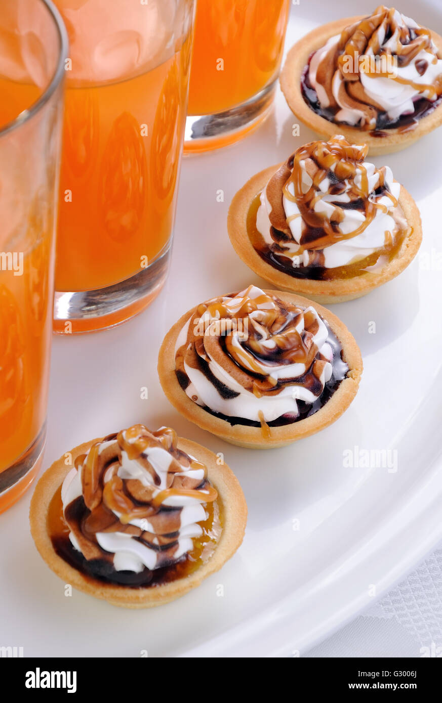 Frollini сakes inceppamento riempiti con panna e cioccolato topping caramel Foto Stock