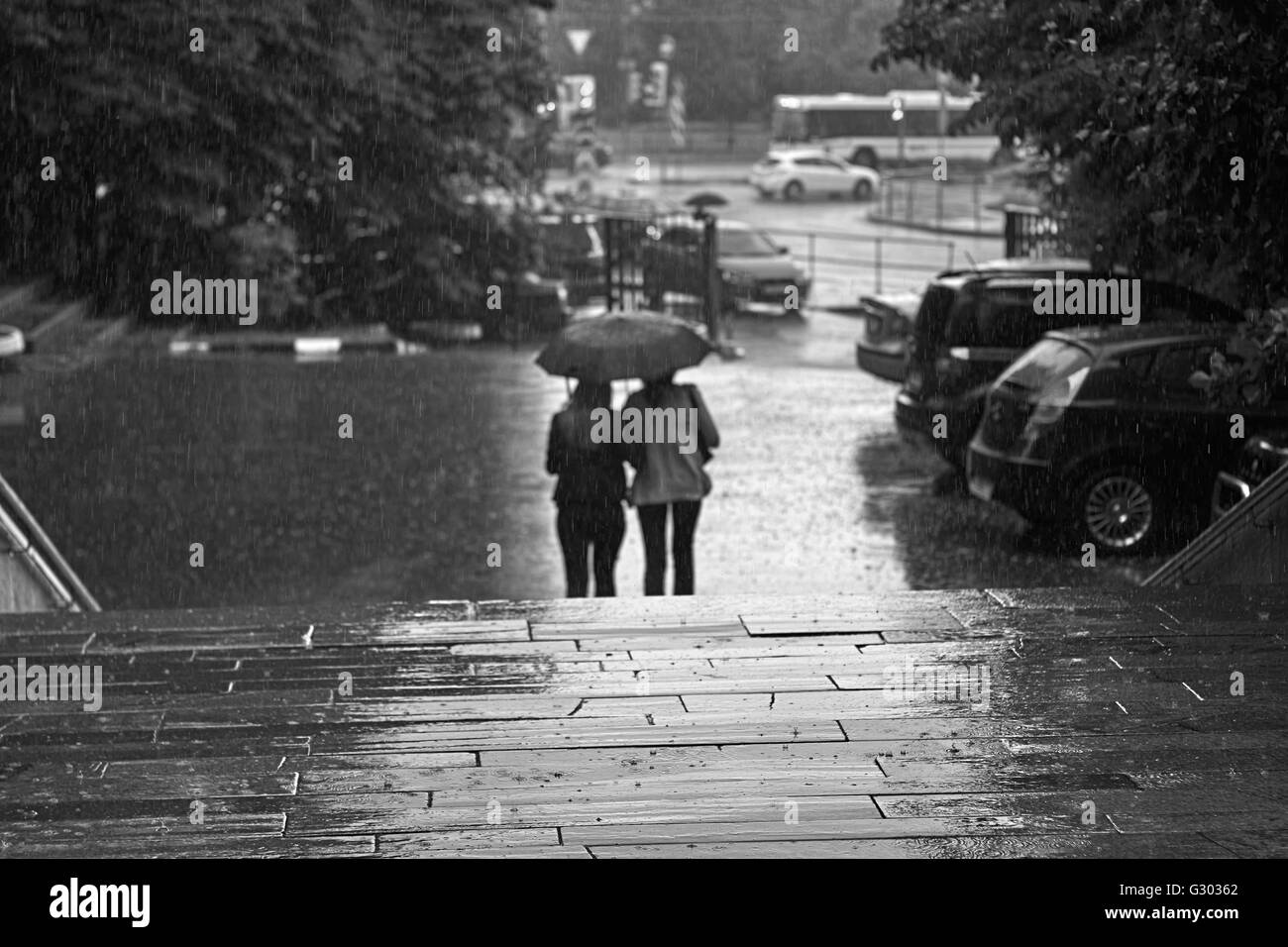 Camminando sotto la pioggia. Sagome di persone sotto la pioggia Foto Stock