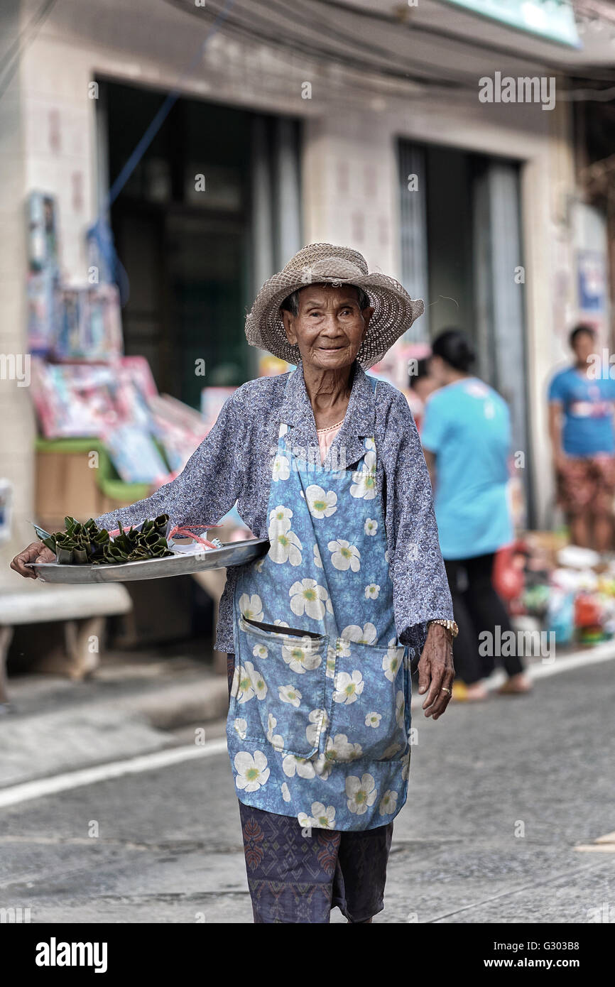 Donna anziana che lavora. Donna anziana che vende cibo per strada. Thailandia, S. E. Asia Foto Stock