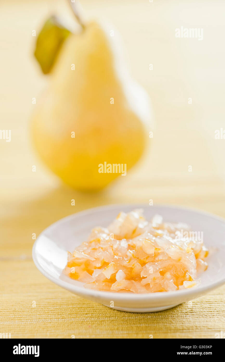 Confettura di frutta fatta da pere con una fresca pera in retro Foto Stock