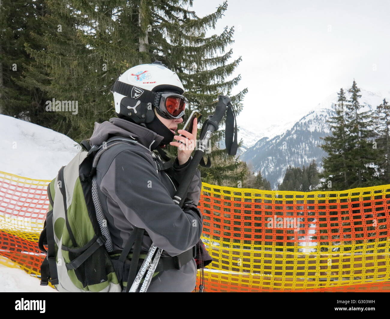 Sciatore su una barriera parla a loro smartphone, St. Anton am Arlberg, Tirolo, Austria, Europa Foto Stock