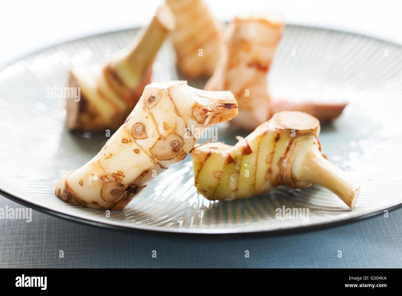 Raw radice commestibili su una piastra. Foto Stock