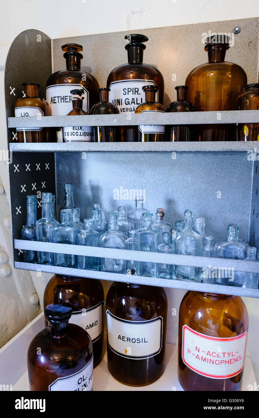 Bottiglie sugli scaffali entro un ambulatorio medico da WW1. Foto Stock