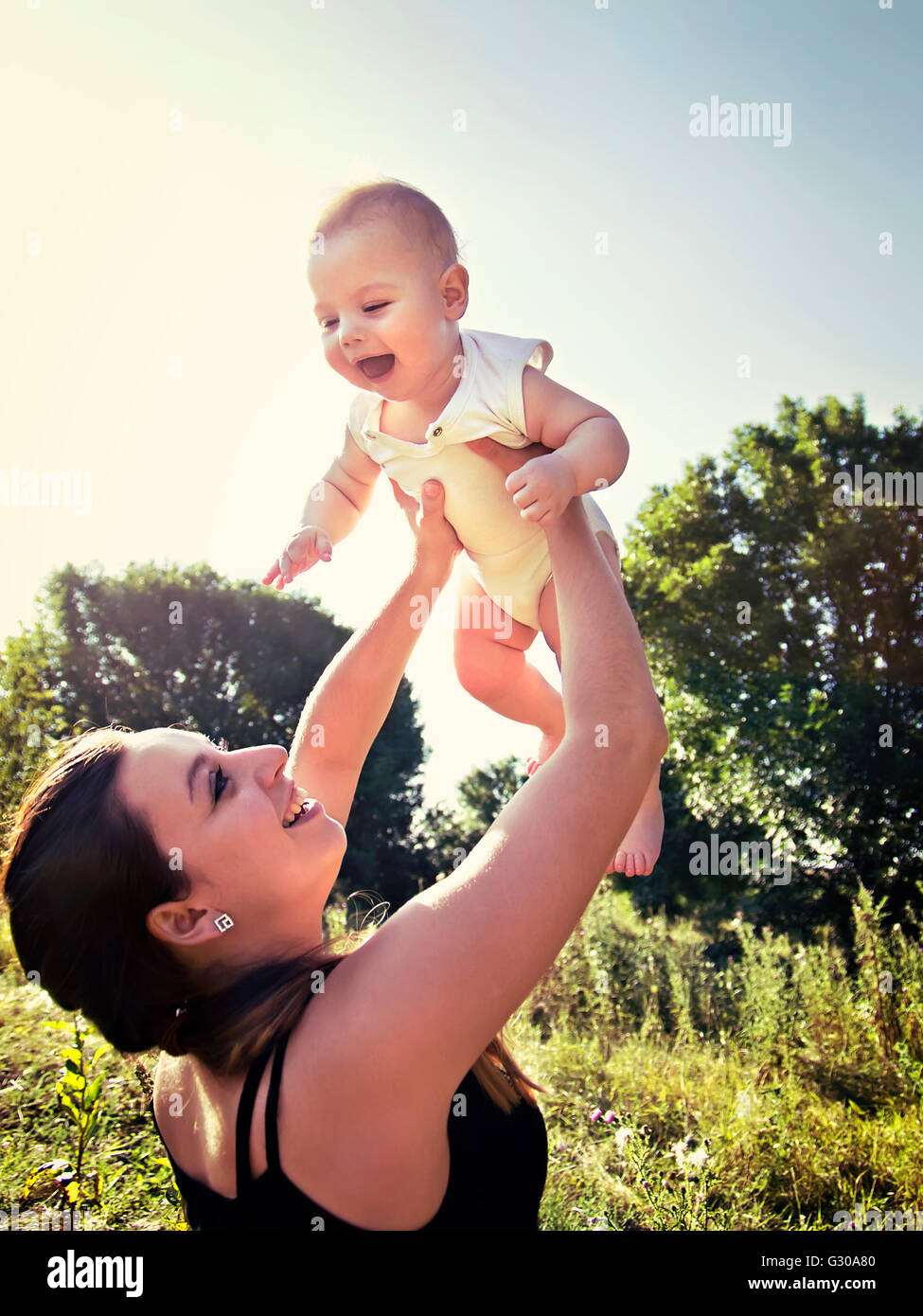 Madre preleva il bambino nelle braccia Foto Stock
