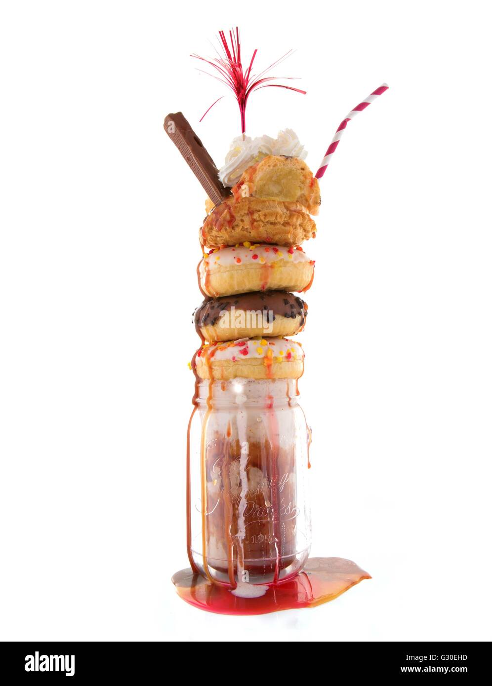 Freakshake decadente con gelato e ciambelle su sfondo bianco Foto Stock