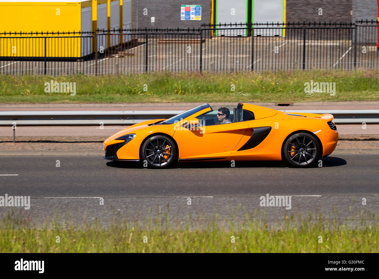 Un lussuoso McLaren MP4-12C Spider convertibile auto sportive che viaggia lungo il Kingsway West a doppia carreggiata a Dundee, Regno Unito Foto Stock