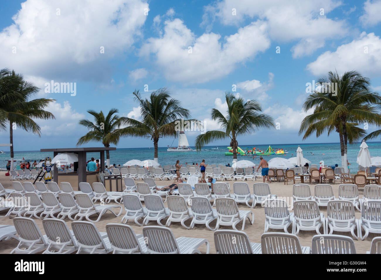 I turisti rilassarsi sotto le palme a Playa Mia Resort. Cozumel, Messico Foto Stock