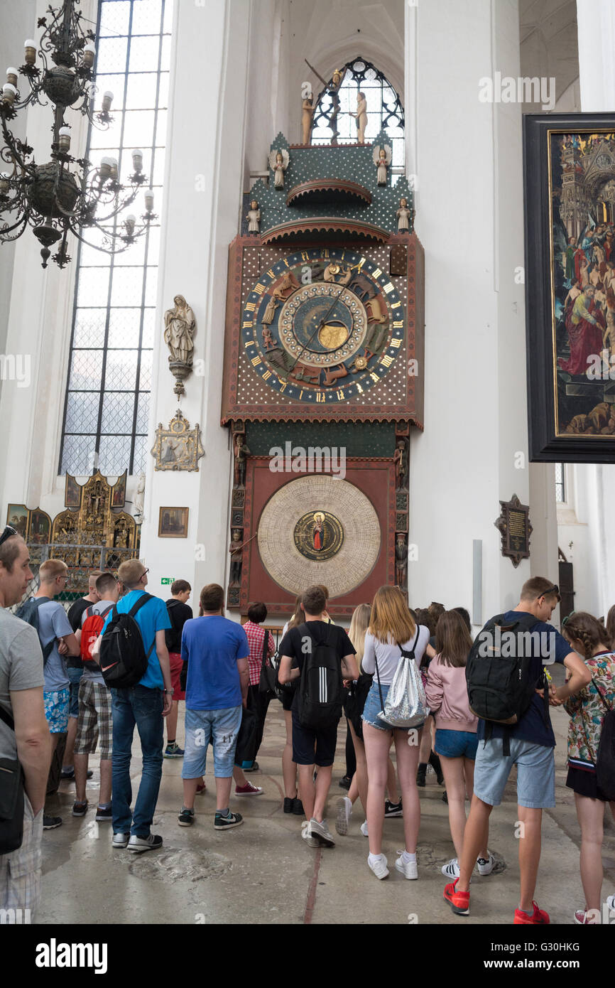 Gli studenti le persone che ricercano il quindicesimo secolo in legno orologio astronomico nella chiesa di Santa Maria, Gdansk Foto Stock