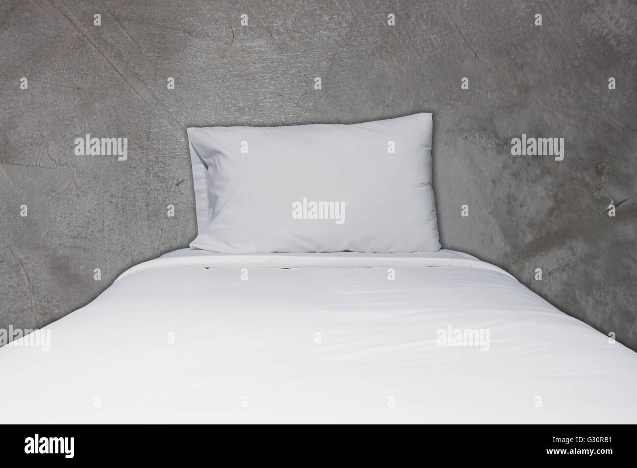 Close up biancheria da letto bianca e cuscino sul concreto sfondo texture Foto Stock