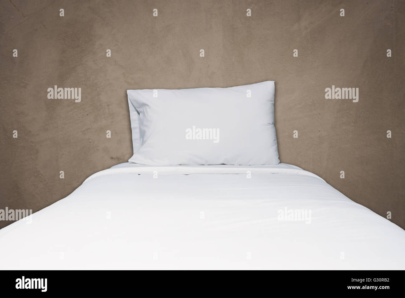 Close up biancheria da letto bianca e cuscino sul cemento grigio Sfondo texture Foto Stock