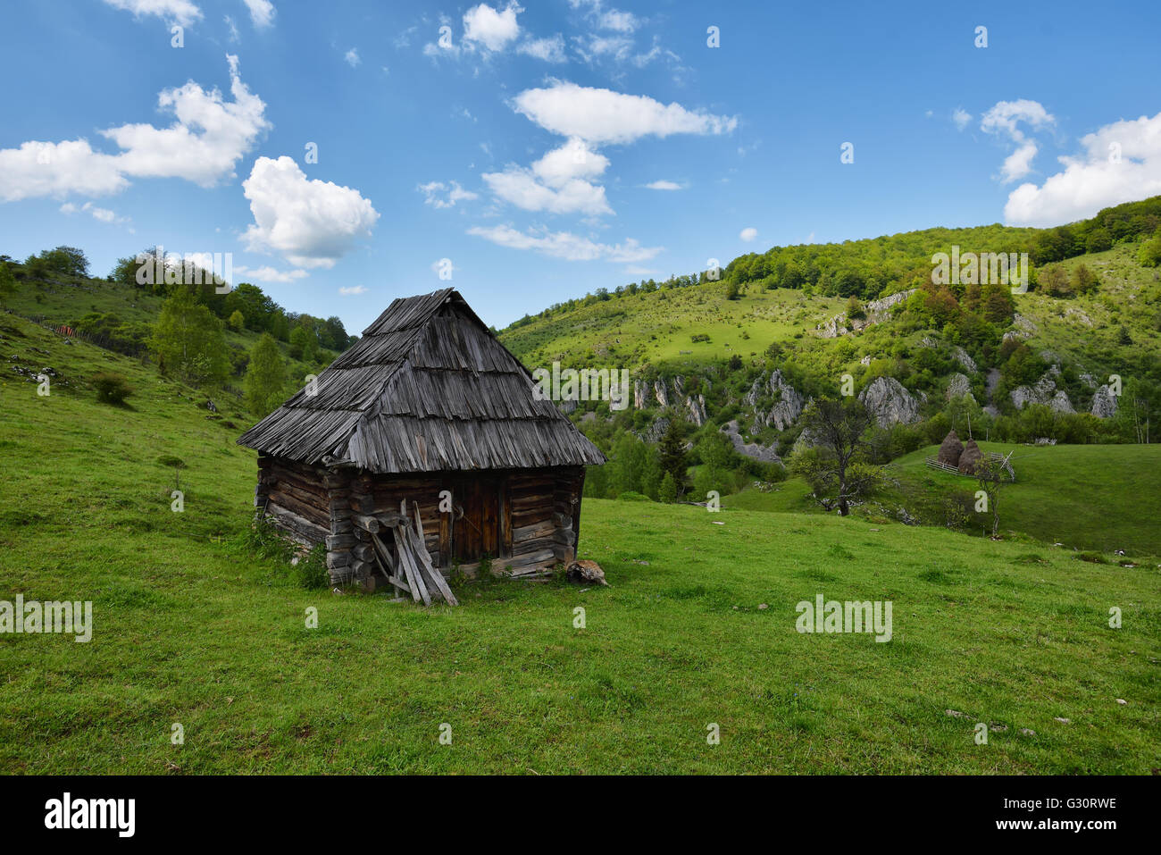 Lonely vecchia casa in legno su una collina contro il cielo nuvoloso Foto Stock