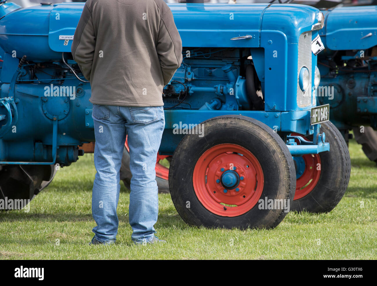 Blu su blu - gli agricoltori in jeans ammira vintage Fordson trattore a Kelso annuali mostrano BVAM Scozia Scotland Foto Stock