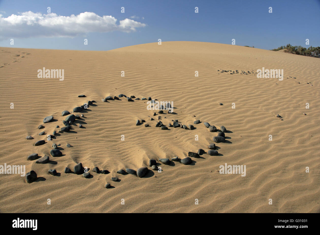 Un cuore costruire fuori di pietre su una duna Foto Stock