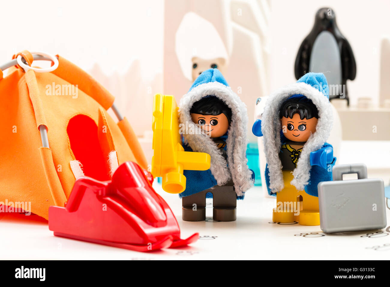 Lego Duplo esplorare artico playset giocattolo. Due personaggi lego, uomo e donna, in base camp, con orso polare, iceberg e penguin dietro. Foto Stock