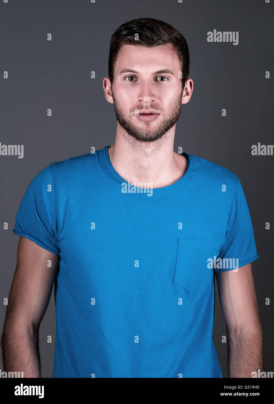 Studio fashion shot: ritratto di un bel giovane uomo in camicia blu Foto Stock