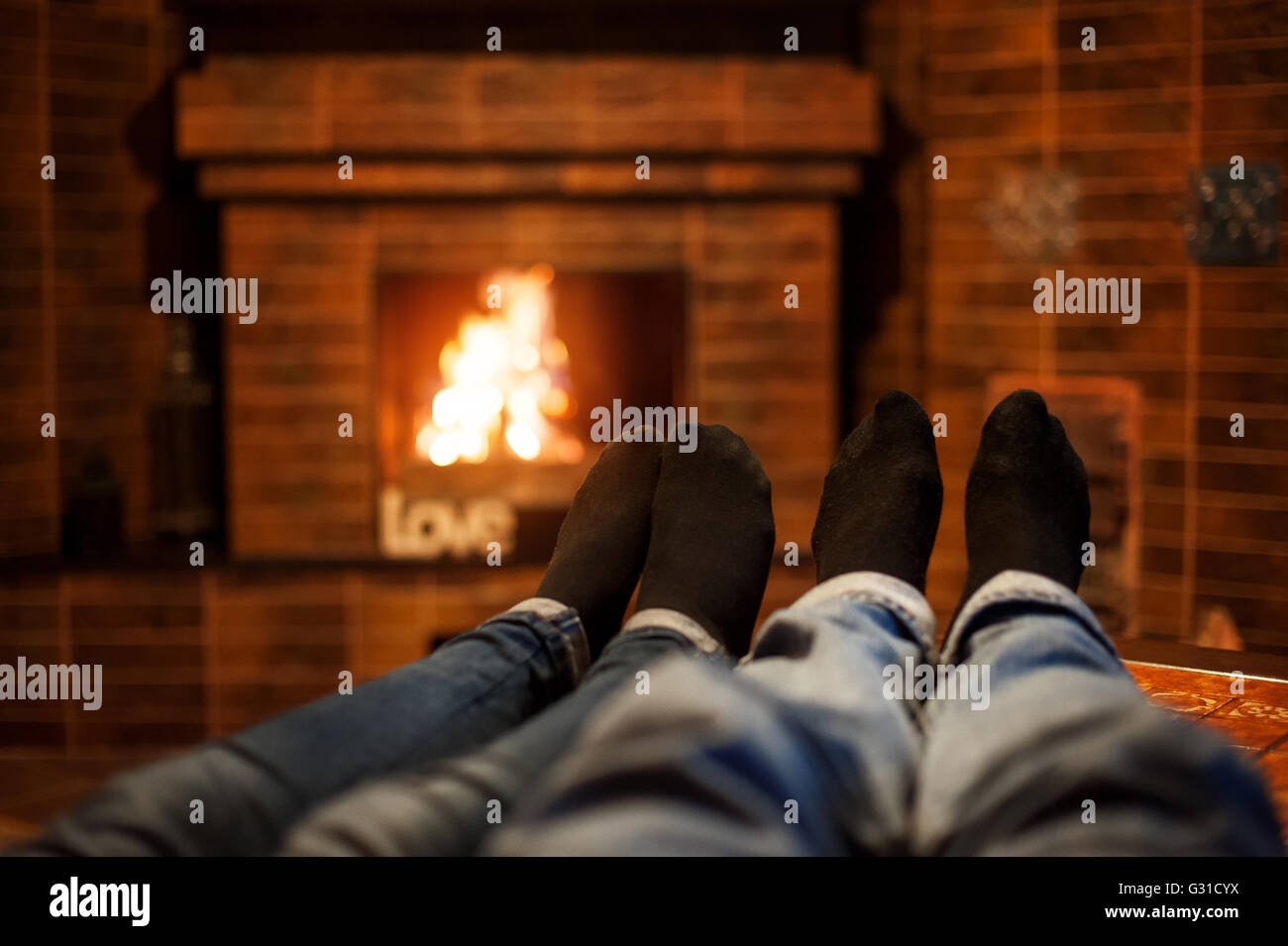 Due coppie gambe sullo sfondo del caminetto Foto Stock