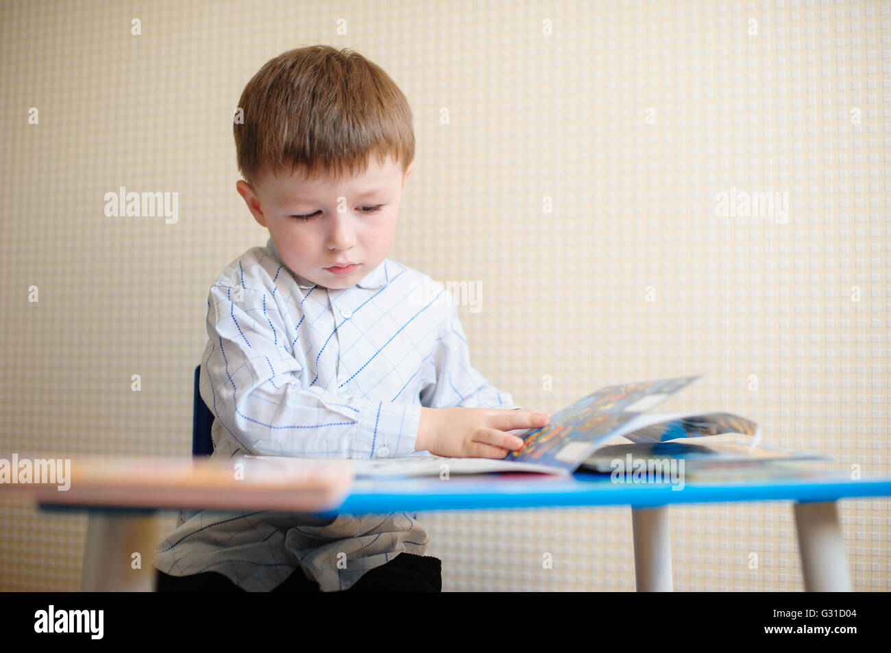 Little Boy al banco la lettura di un libro Foto Stock