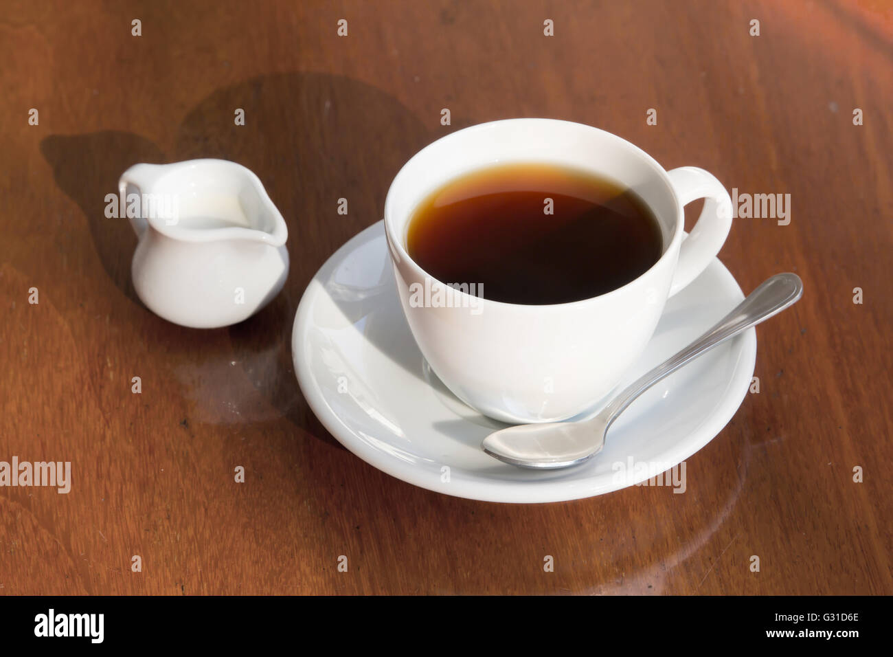 Una tazza di caffè nero e latte sul tavolo di legno. Foto Stock