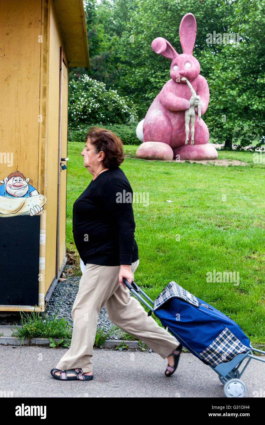 Plzen Statua di un coniglio rosa che mangia umano, scultura in cemento sulla proprietà immobiliare Pilsen Repubblica Ceca coniglietto città Foto Stock