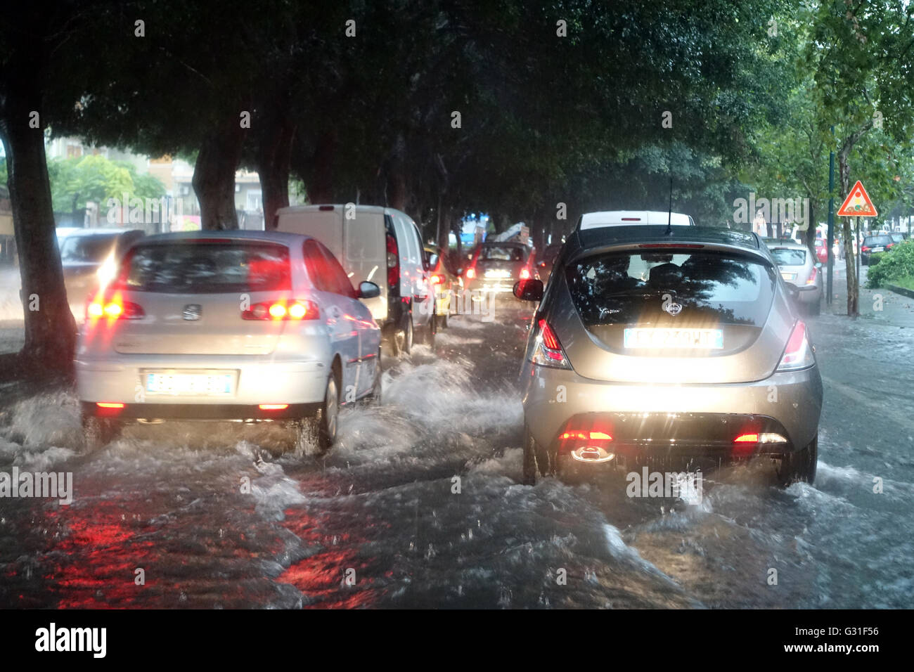 Aci Trezza, Italia, auto drive su un invaso dall'acqua piovana Street Foto Stock