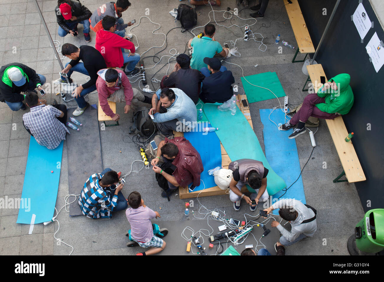 I rifugiati di attendere per treni in Austria e Germania. Il telefono mobile di ricarica e internet point Foto Stock