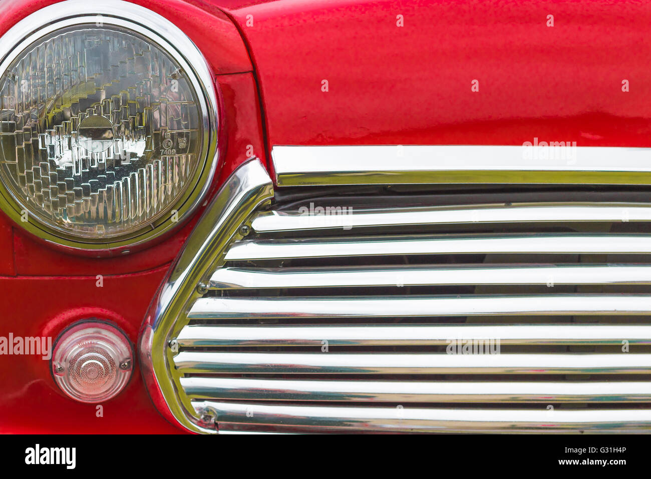 Dettaglio della parte anteriore di un colore rosso brillante degli anni sessanta Mini auto. Foto Stock