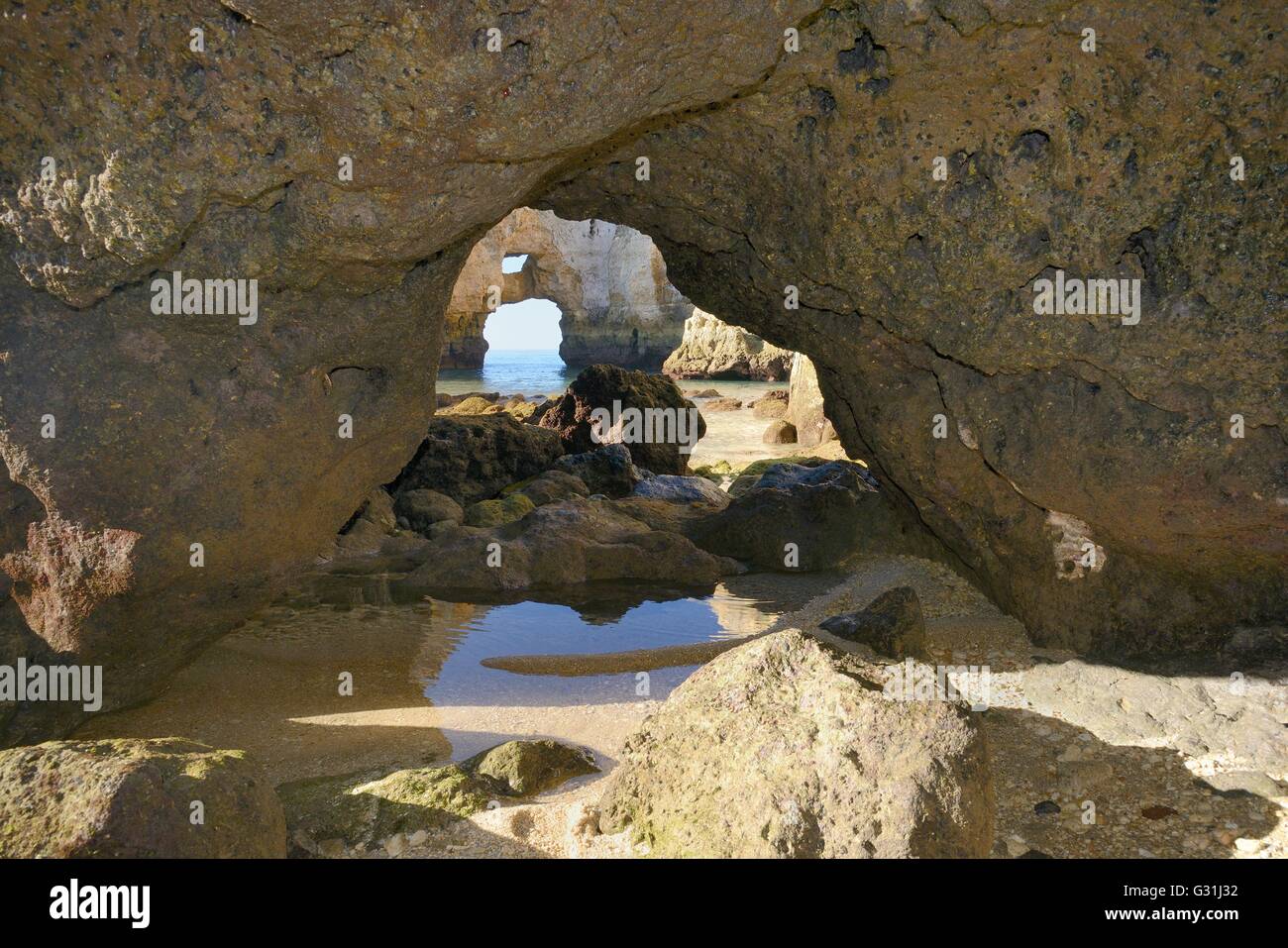 Weathered rocce di arenaria con archi naturali scavate dal mare a Ponta da Piedade a bassa marea, Lagos, Algarve, Portogallo. Foto Stock