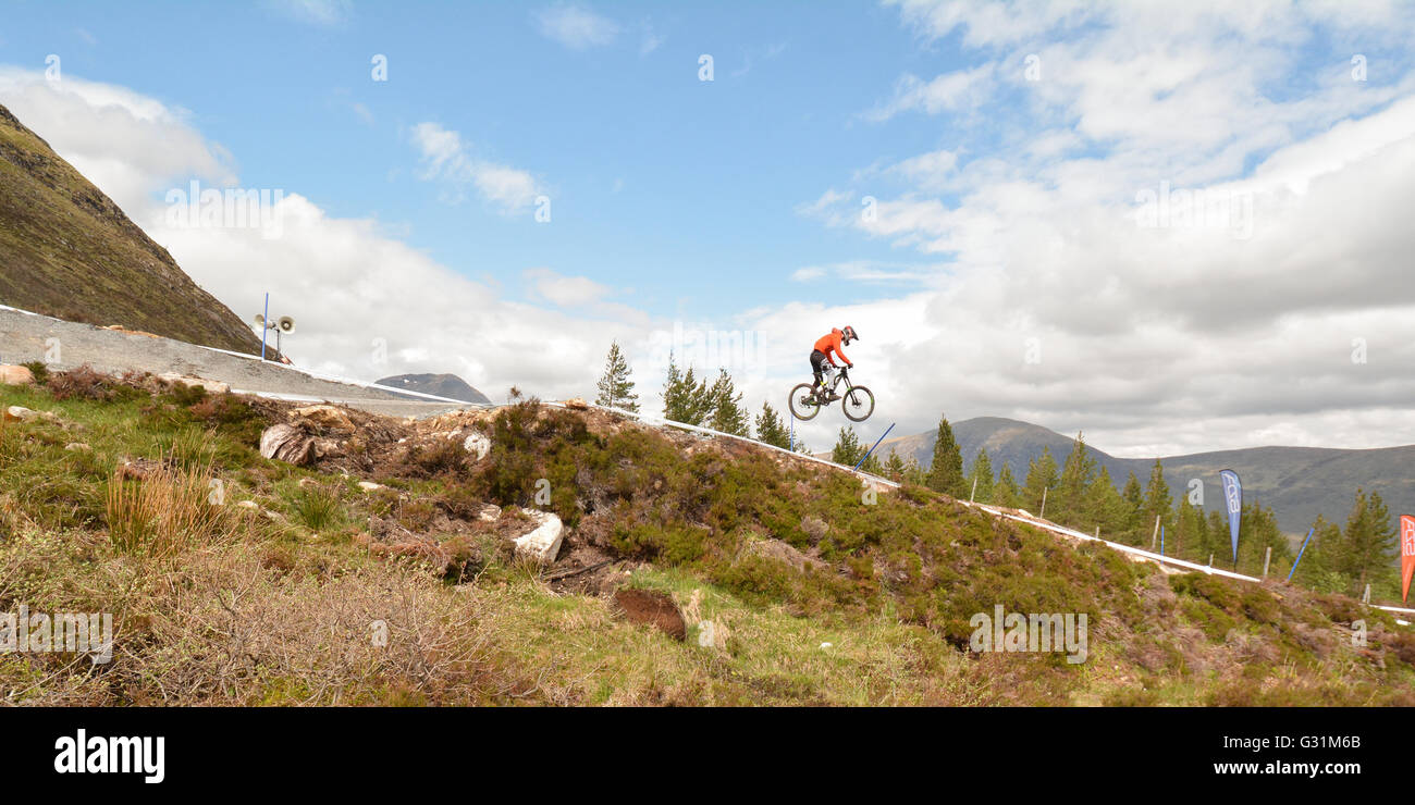 Downhill mountain biker competere nelle Highlands scozzesi in una discesa scozzese gara di associazione a Glencoe, Scotland, Regno Unito Foto Stock
