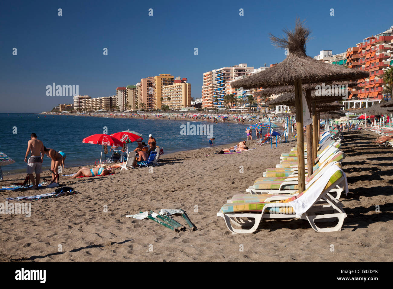 Sedie a sdraio sulla spiaggia sabbiosa, torri di appartamenti e alberghi a retro, Fuengirola, Costa del Sol, Andalusia, Spagna, Europa Foto Stock