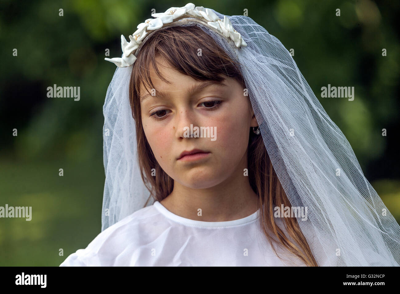 L'età dell'innocenza, bambina, 6 anni una bambina di 7 anni con un vestito bianco, ragazze che giocano Sposa, bambina triste Foto Stock