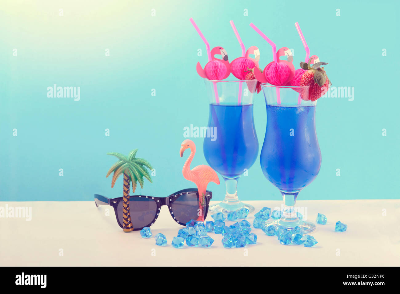 È arrivata l'estate theme Blue Hawaiian cocktail con fenicottero rosa cannucce e strani occhiali da sole Foto Stock