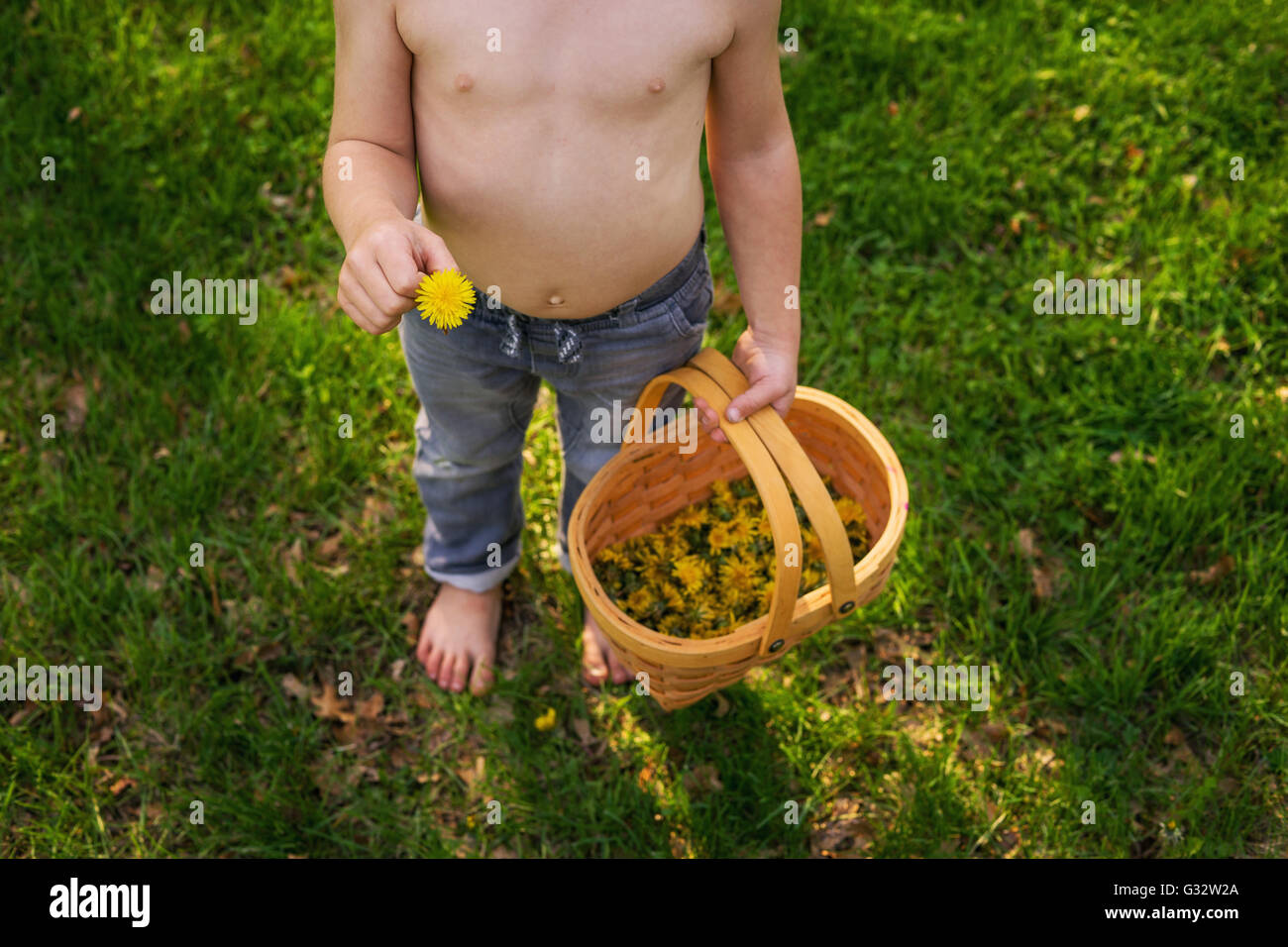 Vista aerea del boy holding tarassaco e cesto pieno di fiori Foto Stock